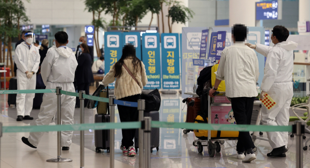 지난달 15일 오후 인천국제공항 제2터미널에서 해외 입국자들이 검역지원단의 안내를 받고 있다./연합뉴스