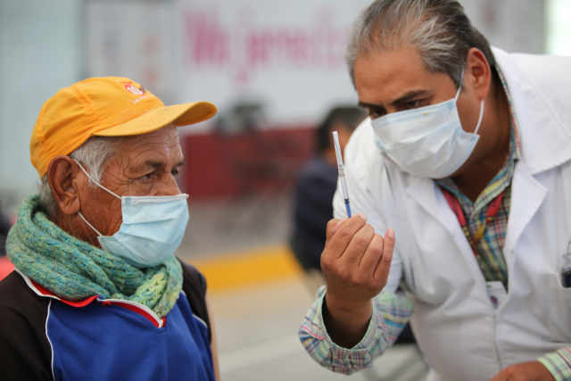 한 간호사가 멕시코 에카텍에 있는 미주문화원에서 한 노인에게 백신을 접종하기 전에 주사기를 보여주고 있다. /AP연합뉴스
