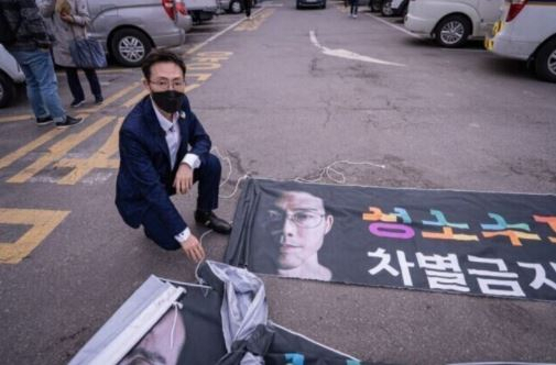 오태양 서울시장 후보가 훼손된 현수막 앞에 앉아있다. /오태양 후보 홈페이지 캡처