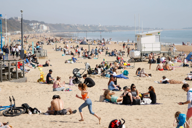 영국 정부가 신종 코로나바이러스 감염증(코로나19) 봉쇄를 완화한 가운데 30일(현지시간) 잉글랜드 남서부 본머스 해변에서 시민들이 따뜻한 봄 날씨를 즐기고 있다. /AFP연합뉴스
