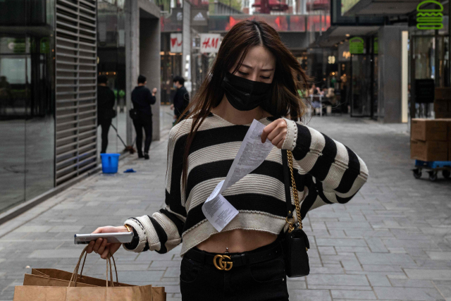 지난 5일 중국 베이징의 한 쇼핑몰에서 물건을 산 여성이 영수증을 확인하고 있다. /AFP연합뉴스