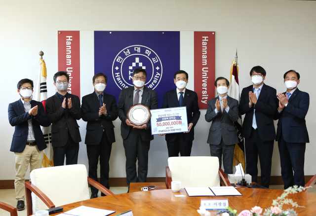 바이오니아 김영훈(사진 왼쪽에서 네번째) 부사장이 한남대 이광섭(″다섯번째) 총장에게 장학금을 기탁하고 기념촬영을 하고 있다. 사진제공=한남대