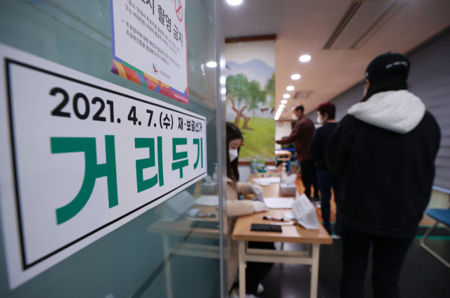 7일 오전 서울 광진구 중곡2동 주민센터에 마련된 투표소 입구에 거리두기 안내문이 부착돼 있다./연합뉴스