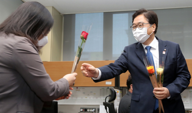 더불어민주당 당권 주자인 우원식 의원(오른쪽)이 8일 전북도의회에서 간담회 개최에 앞서 3·8 세계 여성의 날을 기념해 여성 기자에게 꽃을 선물하고 있다./연합뉴스