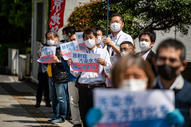 후쿠시마 원전의 오염수 해양 방류 결정을 하루 앞둔 12일 도쿄의 스가 요시히데 일본 총리 관저 앞에서 반핵활동가들이 ‘방사능 오염수를 바다에 버리지 말라’고 적힌 손팻말을 든 채 시위를 벌이고 있다. /AFP연합뉴스