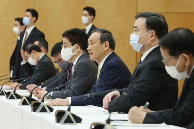 스) 13일 일본 도쿄 총리 집무실에서 열린 각료 회의에서 스가 요시히데(가운데) 총리가 발언하고 있다. 이번 회의에서 일본 정부는 후쿠시마 제1원전 사고로 발생한 방사성 물질 오염수를 바다에 배출하기로 했다. /연합뉴스
