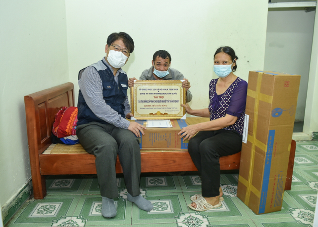 심재극 한미글로벌 베트남법인 상무가 주거환경개선사업 지원을 받은 장애인 가족과 한 자리에 모였다./사진제공=한미글로벌