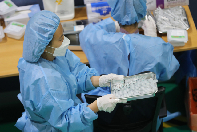 15일 오전 광주 북구 예방접종센터에서 의료진들이 주사기에 옮겨 담은 화이자 백신을 조심스럽게 옮기고 있다. /연합뉴스