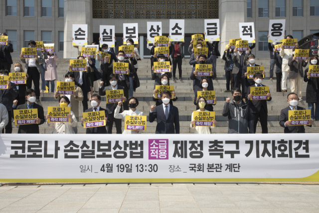 정의당 의원들과 참석자들이 19일 국회 본관 앞 계단에서 코로나19 손실보상법 제정을 촉구하는 기자회견을 하고 있다./ 연합뉴스