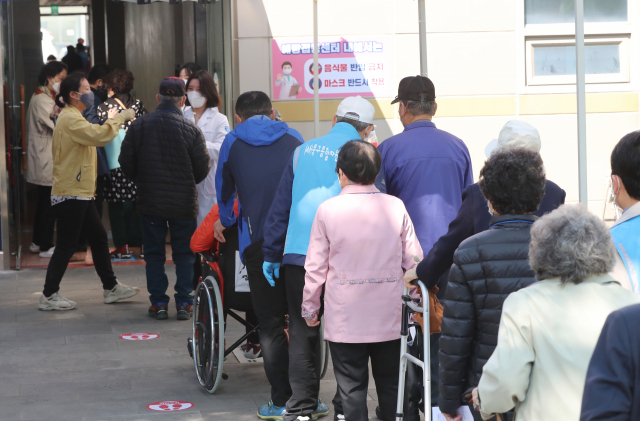 19일 오전 광주 북구 코로나19 예방접종센터 앞에 75세 이상 일반인 주민들이 북구청이 마련한 버스를 타고 화이자 백신을 접종 받기 위해 발열체크를 받고 내부로 이동하고 있다./연합뉴스