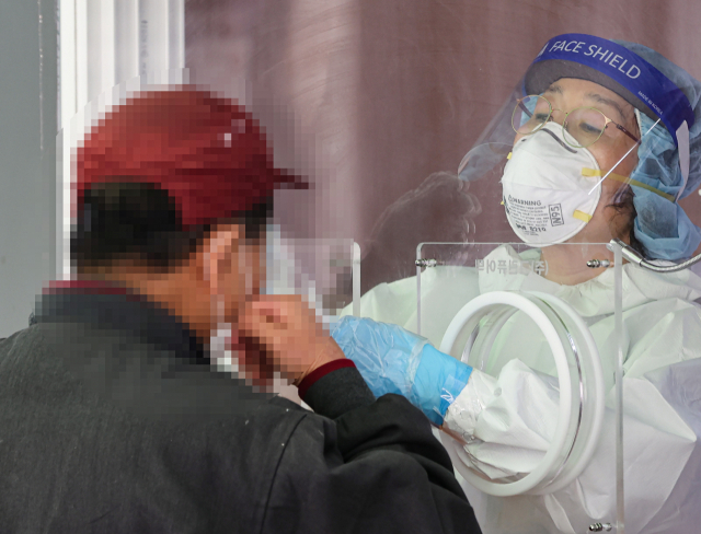 20일 오전 서울 중구 서울역 광장에 설치된 신종 코로나바이러스 감염증(코로나19) 임시 선별검사소에서 한 시민이 검사를 받고 있다. /연합뉴스