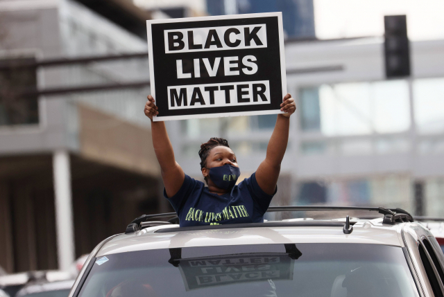 20일(현지 시간) 미국 미네소타 미니애폴리스에서 한 여성이 ‘흑인 목숨도 중요하다’고 적힌 손팻말을 들고 있다./AFP연합뉴스