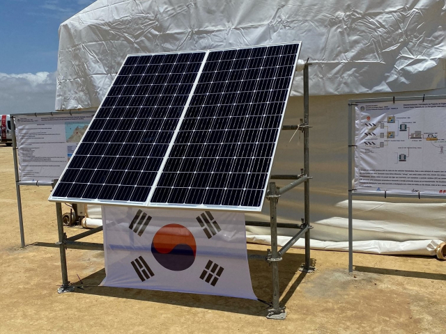 한화큐셀 태양광 모듈이 앙골라 공공 태양광 사업 행사장에 태극기와 함께 설치돼 있다./사진제공=한화