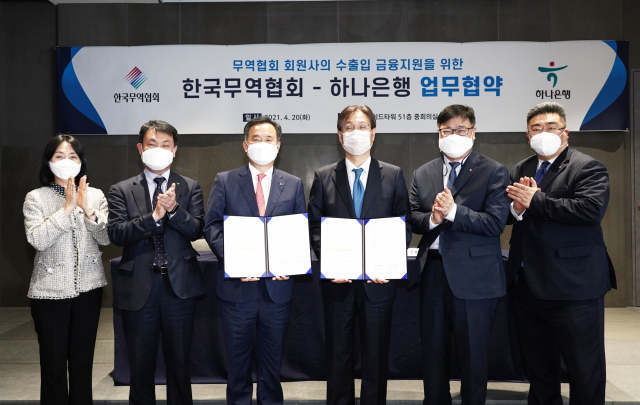 박지환(왼쪽 세번째) 하나은행 CIB그룹 부행장과 이관섭(왼쪽 네번째) 한국무역협회 부회장이 협약서를 펼쳐보이고 있다. /사진제공=무협