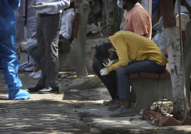 지난 19일(현지 시간) 인도 뉴델리에서 코로나19로 가족을 잃은 한 남성이 머리를 감싼채 눈물을 흘리고 있다./AP연합뉴스