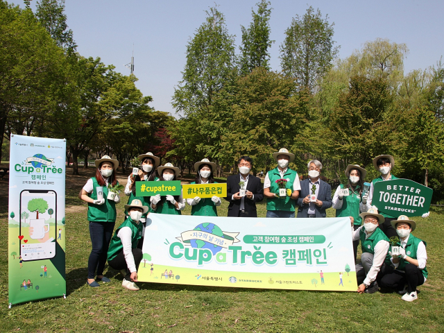 송호섭(뒷줄 오른쪽 네 번째) 스타벅스코리아 대표이사와 임직원, 서울시 관계자들이 21일 서울숲 공원에서 220평 숲 조성을 위한 ‘Cup a Tree(나무품은컵)’ 캠페인을 열고 기념 촬영을 하고 있다. /사진 제공=스타벅스