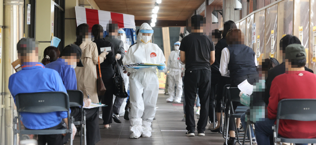 22일 오전 서울 송파구 송파보건소 선별진료소에서 시민들이 신종 코로나바이러스 감염증 검사를 받기 위해 차례를 기다리고 있다. 중앙방역대책본부는 이날 0시 기준으로 신규 확진자가 735명 늘어 누적 11만6,661명이라고 밝혔다. 지난 1월 7일(869명) 이후 105일 만의 최다 기록이기도 하다. /연합뉴스