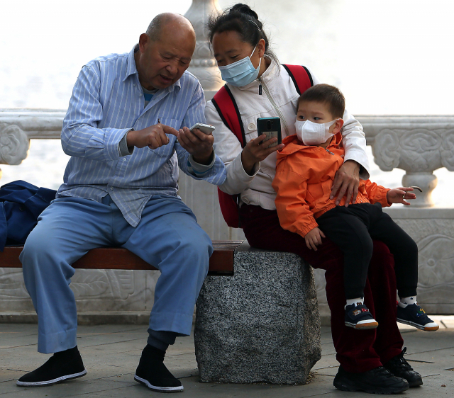중국 베이징의 한 공원에서 노부부가 손주와 함께 시간을 보내고 있다. /UPI연합뉴스
