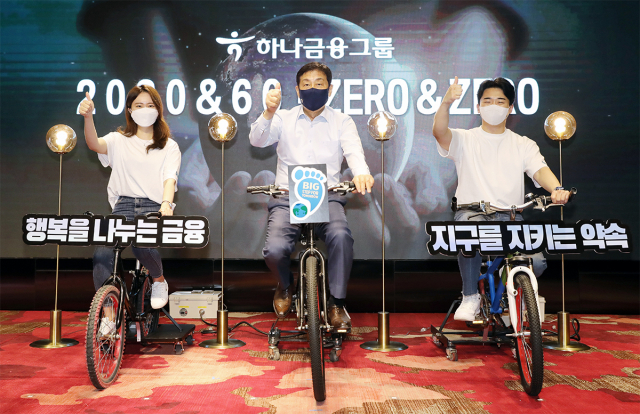 김정태(가운데) 하나금융그룹 회장이 지구의날인 22일 서울 마포구 홍대 ‘H-PULSE’에서 친환경 자가발전 자전거를 타고 있다.