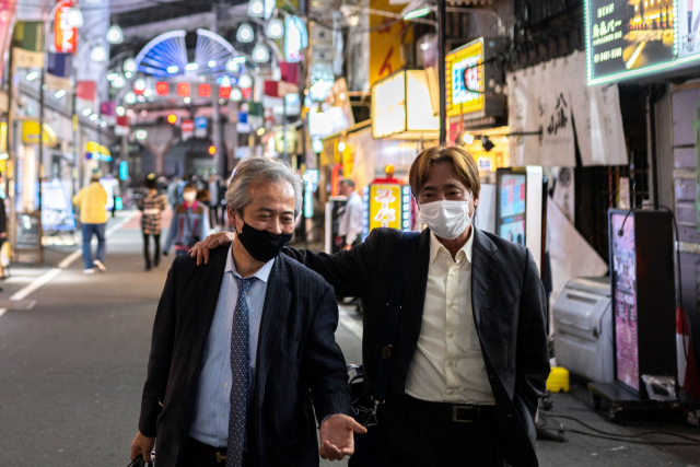 23일 일본 도쿄의 한 거리에서 마스크를 쓴 두 남성이 걸어가고 있다. /AFP연합뉴스