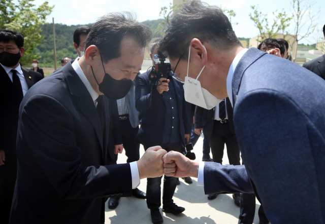 25일 노무현 전 대통령 고향인 경남 김해시 진영읍 봉하마을을 찾은 정세균 전 국무총리(왼쪽)가 김경수 지사와 만나 주먹인사를 하고 있다. /연합뉴스