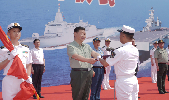 시진핑 중국 국가주석이 지난 23일 하이난함 취역식에서 함장에서 ‘함정명명증서’를 수여하고 있다. /신화연합뉴스