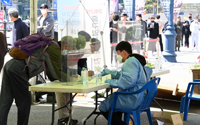 지난 25일 오전 서울역 광장에 마련된 코로나19 선별진료소에서 시민들이 검사를 위해 기다리고 있다. /권욱 기자