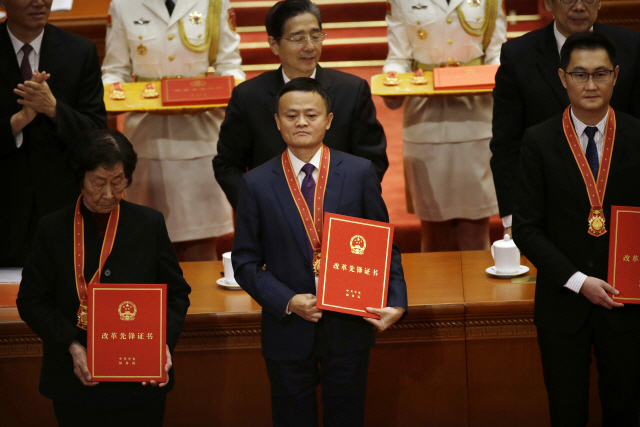 마윈(가운데) 알리바바 창업자가 지난 2018년 12월12일 시진핑 중국 국가주석이 참석한 가운데 베이징 인민대회당에서 진행된 ‘중국 개혁개방 40주년 경축식’에서 유공자로 상을 받고 있다. 그의 오른쪽에 마화텅 텐센트 회장도 보인다. /AP연합뉴스