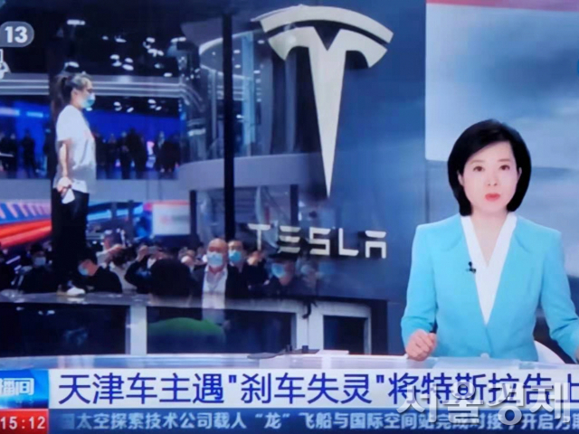 지난 25일 중국중앙방송(CCTV)가 테슬라에 대한 비난성 보도를 내보내고 있다. 지난 19일 상하이모터쇼의 테슬라 차량 위 기습시위(왼쪽 흰옷 입은 여성)는 단골 아이템이다. /CCTV