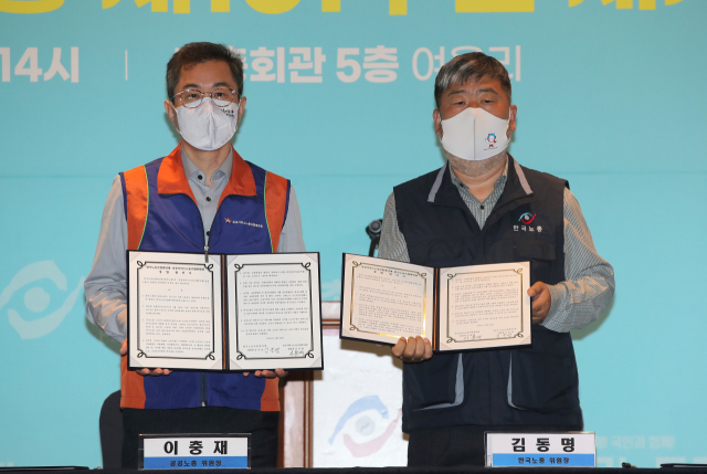 김동명 한국노동조합총연맹 위원장(오른쪽)과 이충재 공공서비스노동조합총연맹 위원장이 서울 한국노총최관에서 통합 합의서에 서명한 뒤 기념촬영을 하고 있다. / 연합뉴스