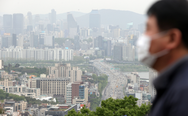 28일 서울 남산공원에서 한 시민이 도심을 내려다보고 있다. /연합뉴스