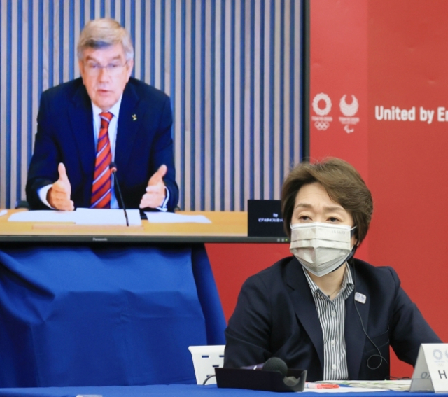 28일 오후 열린 2020도쿄올림픽·패럴림픽 5자 온라인 회의에서 토마스 바흐 국제올림픽위원회(IOC) 위원장이 발언하는 것을 하시모토 세이코(앞쪽) 대회 조직위원회 회장이 듣고 있다./교도연합뉴스