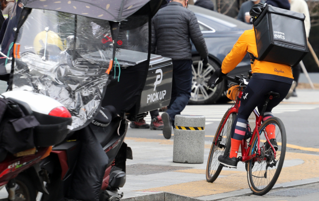 서울시내에서 한 배달업체 소속 배달원이 자전거로 음식을 배달하고 있다. /연합뉴스