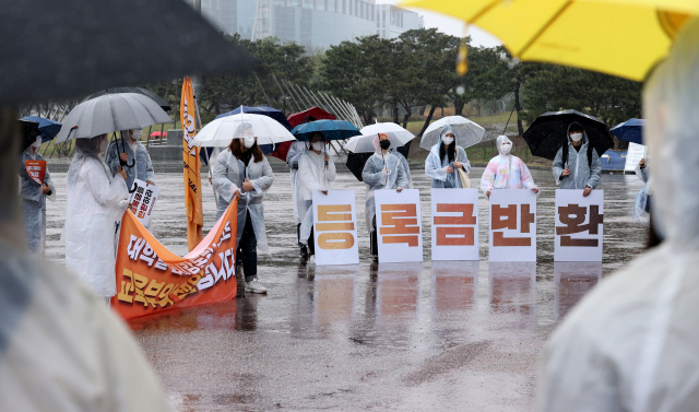 지난 3일 서울 여의도공원에서 2021등록금반환운동본부 주최로 열린 등록금 반환 요구 10km 릴레이 행진에서 참가자들이 행진 출발 전 요구사항이 담긴 팻말을 들고 있다. /연합뉴스