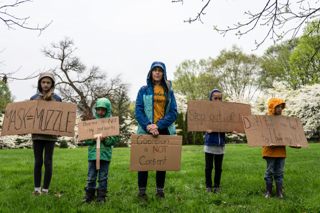 미국 켄터키에서 한 어머니가 자녀들과 함께 코로나19 백신 접종에 반대하는 시위를 벌이고 있다./AFP연합뉴스
