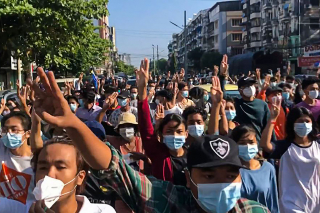 미얀마 최대 도시 양곤에서 2일(현지시간) 군부 쿠데타 규탄 시위대가 군경의 단속을 피하려고 플래시몹 형태의 거리 시위를 벌이며 독재에 대한 저항의 상징인 '세 손가락 경례'를 하고 있다. /AFP연합뉴스