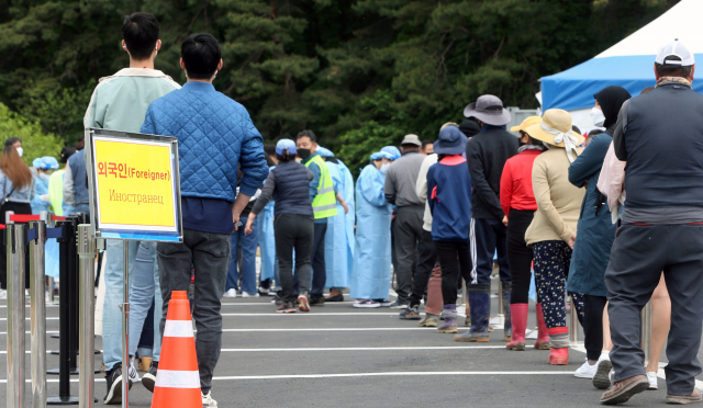 4일 강원 강릉시 보건소 앞에서 외국인 근로자들이 코로나19 검사를 받기 위해 대기하고 있다. /연합뉴스