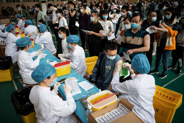 코로나19 발원지인 중국 허베이성 우한에서 지난달 28일 대학생들이 줄지어 중국 제약사 시노팜의 백신 주사를 맞고 있다. /연합뉴스