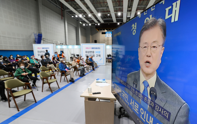 10일 오전 서울 마포구 마포구민체육센터에 마련된 마포 코로나19 예방접종센터에서 이날 코로나19 화이자 백신 2차 접종을 마친 어르신들이 텔레비전으로 중계되는 문재인 대통령 취임 4주년 특별 연설을 지켜보고 있다./연합뉴스