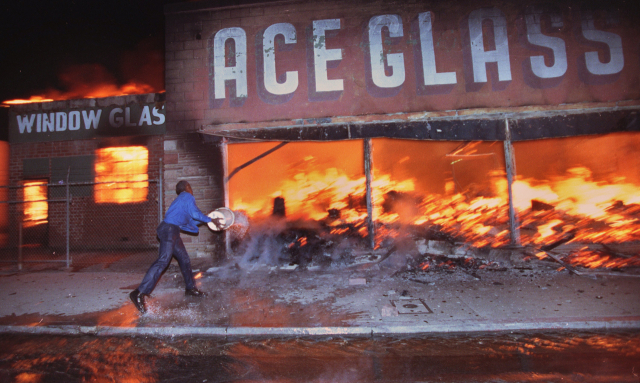 지난 1992년 흑인들의 LA 폭동 당시 주인이 불타는 가게에 물을 끼얹고 있으나 어림도 없는 모습이다..