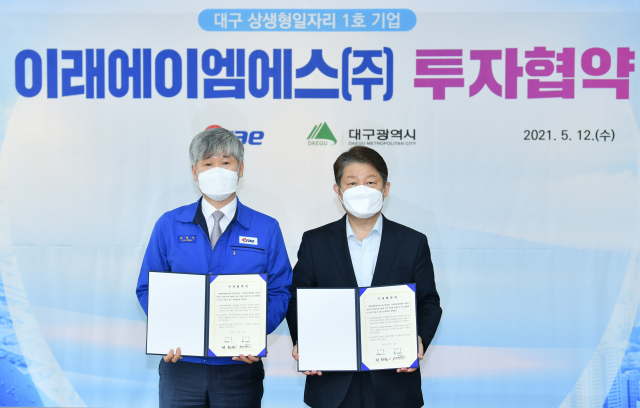 권영진(오른쪽) 대구시장과 김용중 이래AMS 회장이 12일 미래형 자동차 분야 투자협약을 체결한 뒤 기념촬영을 하고 있다./제공=대구시