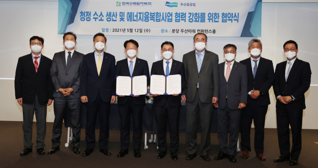 12일 분당두산타워에서 열린 ‘청정수소 생산 및 에너지 융복합사업 협력 강화를 위한 협약식’에서 김상돈(왼쪽 네번째) 한수원 성장사업본부장과 정연인(왼쪽 다섯번째) 두산중공업 사장이 서명을 마친 후 관계자들과 기념촬영을 하고 있다./사진 제공=두산중공업