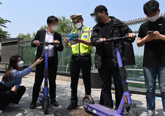 개정 도로교통법 시행 첫날인 13일 서울 영등포구 여의도한강공원 인근에서 서울영등포경찰서 소속 경찰들이 시민들을 대상으로 계도 활동을 벌이고 있다./성형주 기자