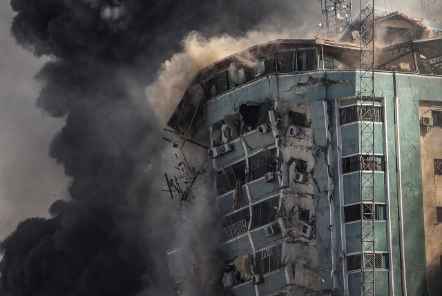 AP통신과 알자지라 방송 등 외국 언론의 지국이 주로 입주한 팔레스타인 가자지구 내 12층 건물인 ‘잘라 타워’가 15일(현지시간) 이스라엘의 공습을 받고 무너져 내리고 있다. 이스라엘 측은 폭격 1시간 전 모두 대피하라고 경고한 뒤 공습을 감행하고는 “이 건물이 하마스에 의해 군사적으로 사용됐다”고 밝혔다. /EPA연합뉴스