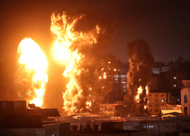 17일(현지시간) 이스라엘군의 공습을 받은 팔레스타인 가자지구의 건물들에서 화염과 연기가 치솟고 있다./AFP연합뉴스