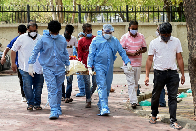 인도 서부 아메다바드의 한 화장장에서 8일(현지시간) 신종 코로나바이러스 감염증(코로나19) 사망자 유족들이 시신을 들것에 실어 옮기고 있다. /AFP연합뉴스