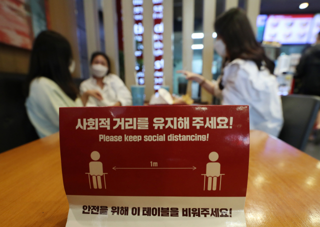 지난달 26일 경북 고령의 한 패스트푸드 매장에 손님들이 5인 미만만 함께 앉아 거리두기를 이어가고 있다. /연합뉴스
