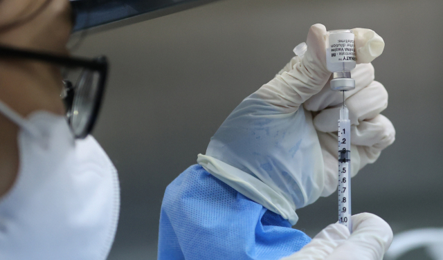 지난 17일 오후 서울 동대문구체육관에 마련된 코로나 백신 접종센터에서 관계자가 시민들이 접종할 화이자 백신을 준비하고 있다./연합뉴스 cityboy@yna.co.kr (끝)