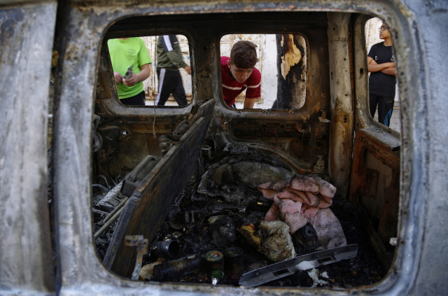 19일(현지 시간) 가자지구에서 한 팔레스타인 어린이가 이스라엘 군의 폭격으로 피해를 입은 차량을 들여다보고 있다. /AP연합뉴스