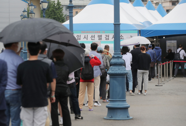 20일 오전 서울역광장에 마련된 임시선별진료소에서 시민들이 코로나19 검사를 받기 위해 줄을 서 있다. /연합뉴스
